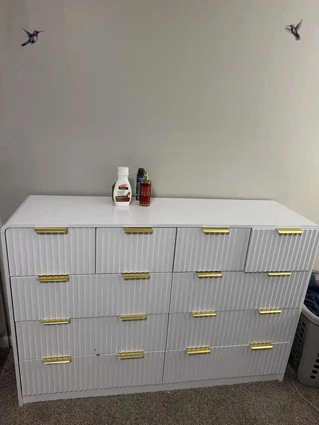 Assembled white dresser with fluted drawer fronts and gold pulls